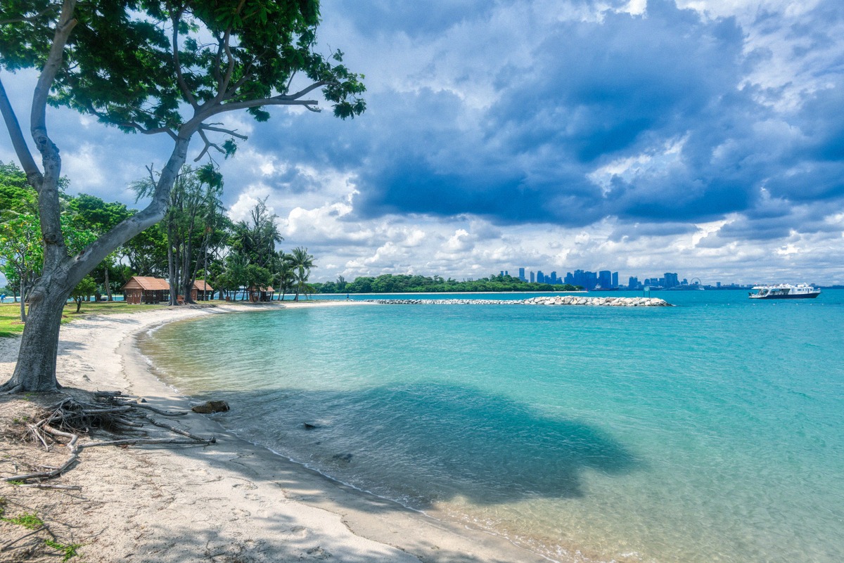 Strand auf Kusu Island mit Singapurs Skyline am Horizont